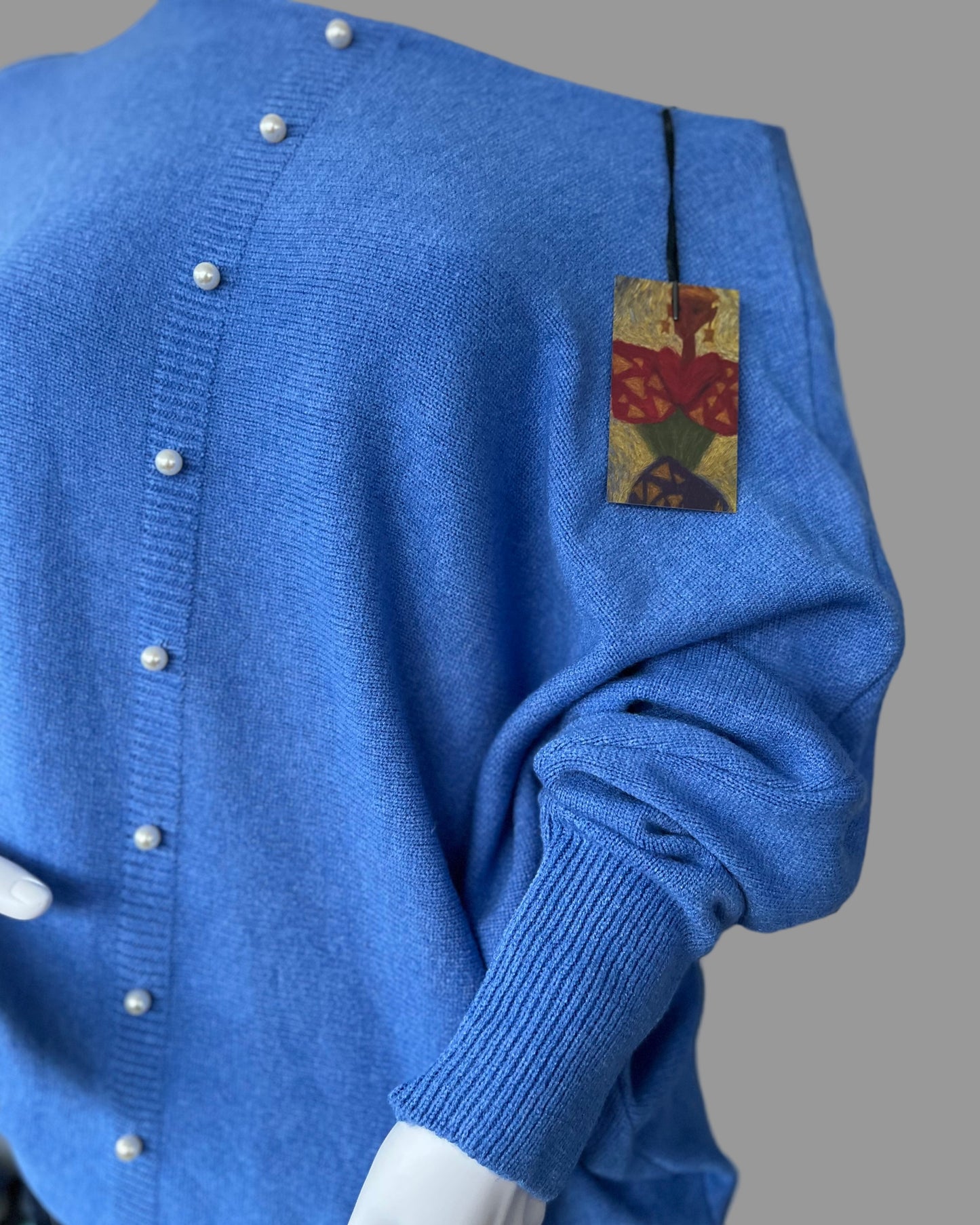 Denim blue jumper with elegant pearl detailing on the back
